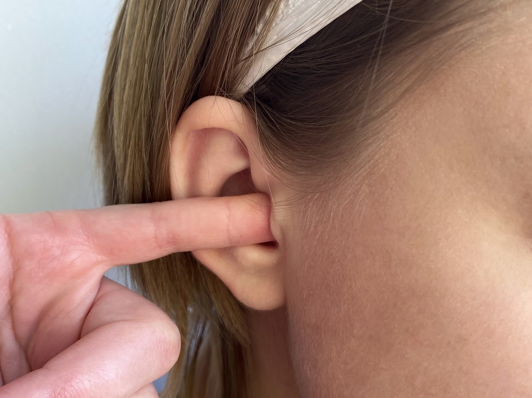 вставьте мизинец в ухо